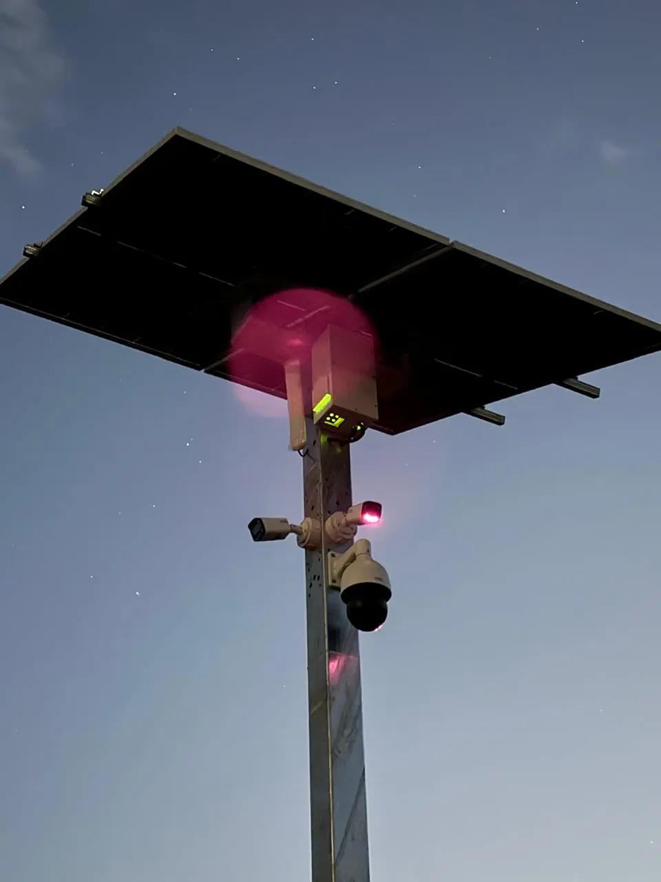 Solar-powered surveillance camera mounted on an elevated pole at a remote site